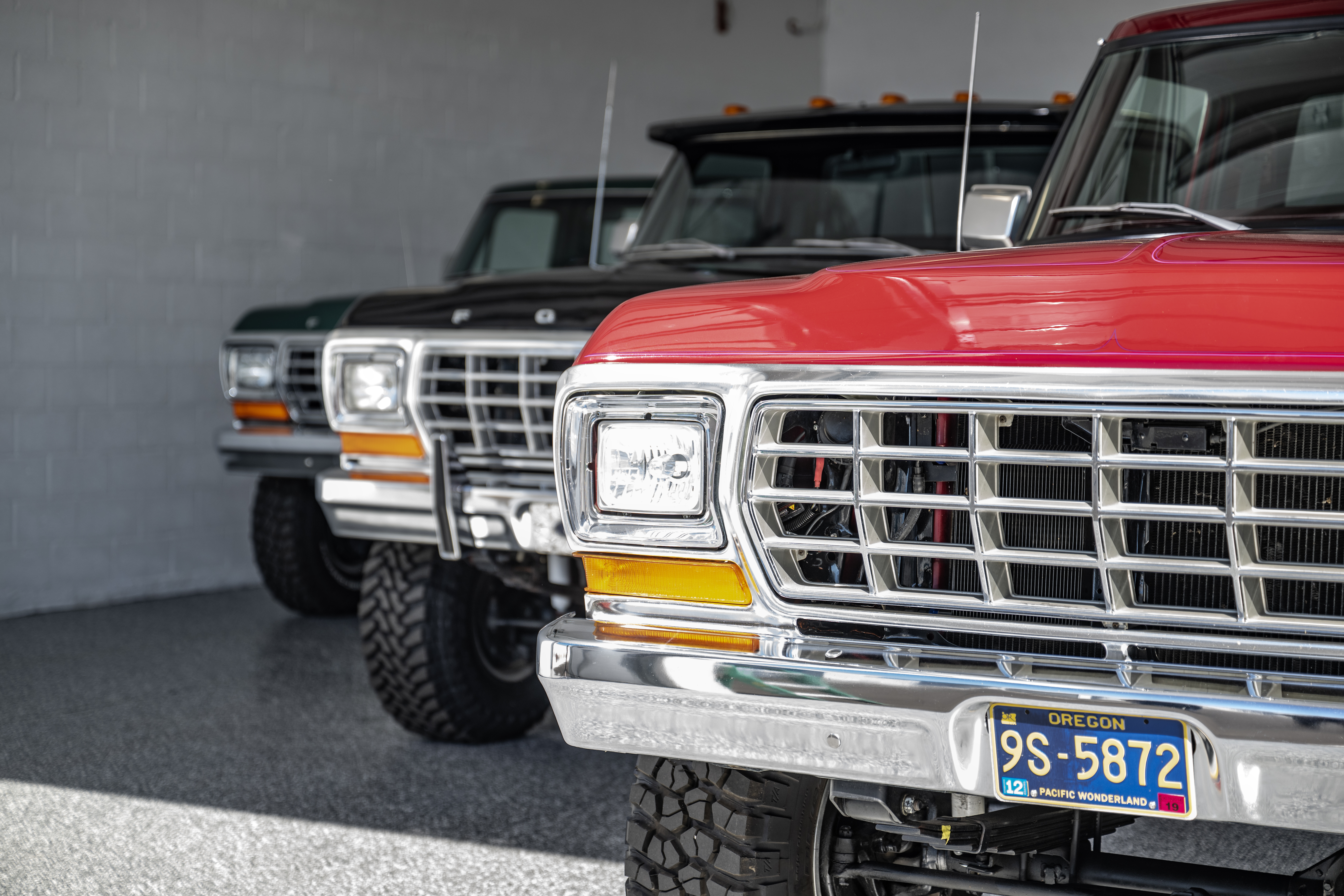 Row of restored classic Ford pickup trucks parked inside a clean, climate-controlled private garage at MetroMaxx RV & Boat Storage in Fort Myers, Florida.